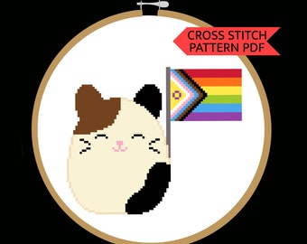 May include: Cross stitch pattern PDF of a cute cartoon cat holding a pride flag with the text "CROSS STITCH PATTERN PDF".