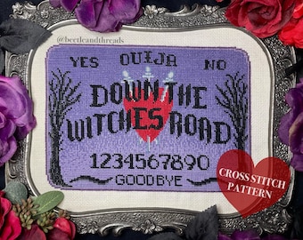 May include: A cross-stitch pattern of a Ouija board with the text "YES", "NO", "DOWN THE WITCHES ROAD", numbers, and "GOODBYE". The design features a purple background, black lettering, and a red heart. The words "CROSS STITCH PATTERN" are in a red heart.