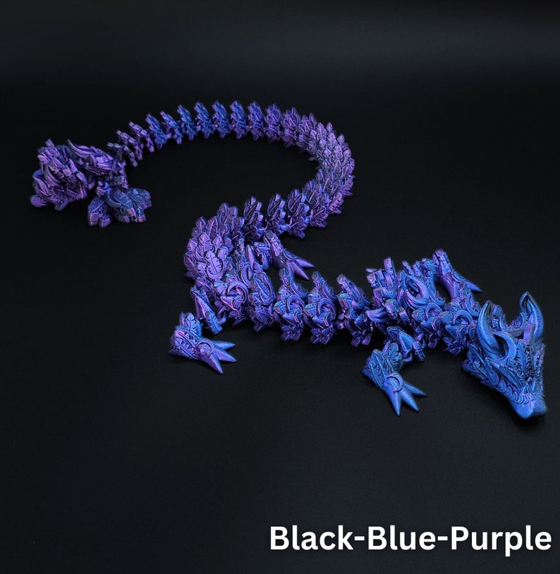 May include: A flexible, articulated dragon figurine featuring a metallic, iridescent finish in shades of black, blue, and purple. The creature has a segmented body with intricate scale detailing, sharp claws, and horns. The text Black-Blue-Purple is visible.