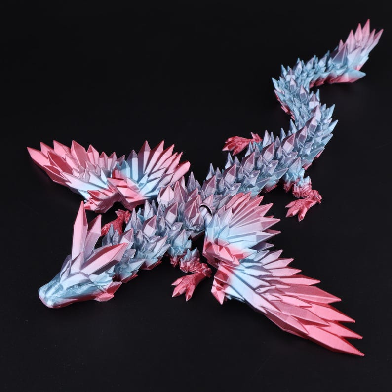 Puede incluir: Una figura de drag&oacute;n multiarticulada con un esquema de color degradado que transita de rosa met&aacute;lico a azul claro. La criatura est&aacute; cubierta de escamas y p&uacute;as geom&eacute;tricas afiladas en forma de cristal a lo largo del cuerpo, alas y cola.