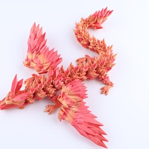 Puede incluir: Una figura de drag&oacute;n con una estructura cristalina facetada y un degradado de color que va del rojo intenso al naranja claro. La criatura tiene alas articuladas, una larga cola segmentada y p&uacute;as geom&eacute;tricas afiladas a lo largo del cuerpo.