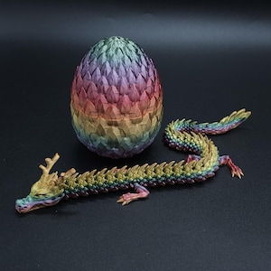 May include: A rainbow dragon figurine with a matching rainbow dragon egg. The dragon is curled up with its head facing the egg. The dragon has a long tail and a spiky back.