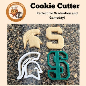 May include: A set of four cookie cutters, two are white and two are green. The white cutters are a Spartan helmet and the letter S. The green cutters are the letter S and a Spartan helmet.