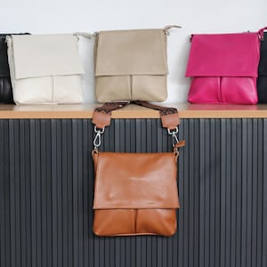 Peut inclure: Sacs &agrave; bandouli&egrave;re en cuir de diff&eacute;rentes couleurs, dont beige, cr&egrave;me, rose et noir. Les sacs ont une fermeture &agrave; rabat et une forme rectangulaire. Un sac est suspendu par une bandouli&egrave;re &agrave; motifs.