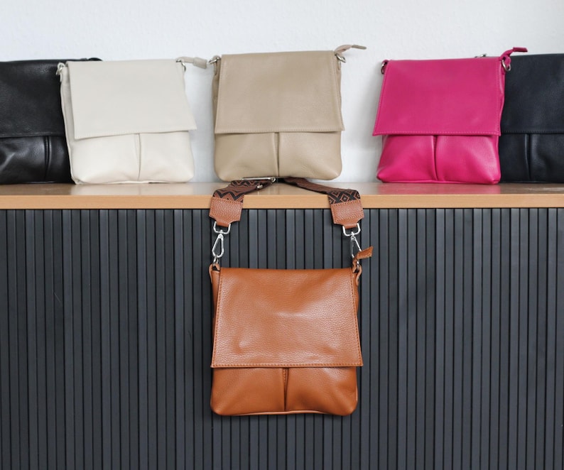 Peut inclure: Sacs &agrave; bandouli&egrave;re en cuir de diff&eacute;rentes couleurs, dont beige, cr&egrave;me, rose et noir. Les sacs ont une fermeture &agrave; rabat et une forme rectangulaire. Un sac est suspendu par une bandouli&egrave;re &agrave; motifs.