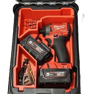 Peut inclure: Un organisateur d'outils noir et rouge avec une perceuse Milwaukee Fuel et deux batteries RedLithium M18 de 5,0 Ah. L'organisateur est doté d'un insert en mousse avec des découpes pour les outils et les batteries. L'organisateur est ouvert et les outils sont visibles.
