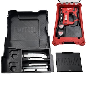 Puede incluir: Una caja de herramientas roja y negra con el texto "TIDYTOOL" en relieve en la tapa y otros componentes. La caja contiene una grapadora Milwaukee roja, dos baterías y un organizador negro con grapas.