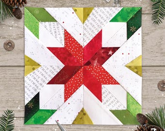 May include: A square quilt block featuring a central eight-pointed star in shades of red with white polka dots and solid red fabric. The background consists of white fabric printed with the text Merry Christmas, accented by green and gold corners.