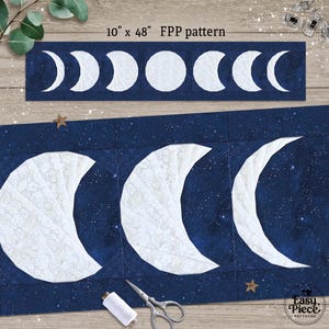 May include: A navy blue and white fabric panel with a moon phase design. The panel measures 25.4 cm by 121.9 cm. The design includes crescent moons and a full moon. The text "10" x 48" FPP pattern" is visible.