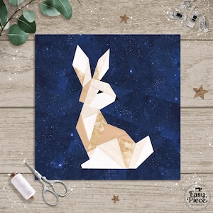 May include: A geometric paper piecing pattern of a rabbit, featuring white, tan, and patterned fabric pieces. The rabbit is set against a dark blue starry background. The Easy Piece Patterns logo is in the lower right corner.