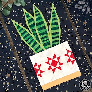 May include: A fabric quilt block featuring a green striped snake plant in a white pot with red star patterns. The background is dark navy blue with gold stars. A logo in the corner reads Easy Piece Patterns with a sewing machine icon.