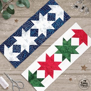 May include: Two rectangular quilt blocks featuring star patterns. One block has navy blue fabric with white dots and snowflakes paired with white stars. The other block features alternating red and green fabric stars with floral patterns on white.