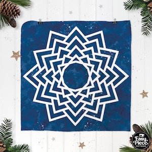 May include: A blue fabric square with a white geometric starburst design. The starburst is made up of multiple layers of white triangles that create a 3D effect. The fabric has a subtle speckled pattern.