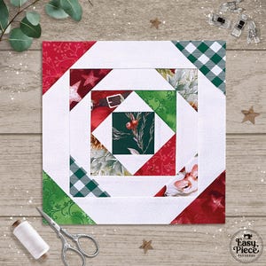 Op de afbeelding: Een vierkant quiltblok met een kerstthema. Het ontwerp bevat rode, groene en witte stoffen gerangschikt in een geometrisch patroon. De middelste vierkant heeft een groene achtergrond met bessen en bladeren. Witte randen en rode en groene accenten omringen het blok.