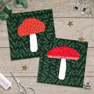 Può includere: Due quadrati di tessuto con disegni di funghi. I funghi hanno cappelli rossi con pois bianchi e gambi bianchi, su uno sfondo verde scuro a foglie. Sono visibili anche strumenti di cucito e decorazioni a forma di stella.