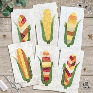 May include: Six fabric art pieces featuring corn on the cob designs. Each piece has a white background with a floral pattern and a colorful corn design. Green leaves and a brown base complete the corn. The Easy Piece Patterns logo is in the bottom right corner.