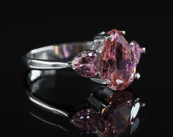 Anillo de compromiso de plata de ley con tres piedras y circonita cúbica rosa talla pera.