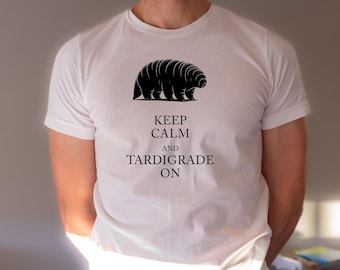 Puede incluir: Camiseta blanca con una ilustración negra de un tardígrado y el texto "Keep Calm and Tardigrade On."