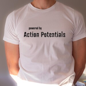 May include: White t-shirt with the text "powered by Action Potentials" printed on the front.