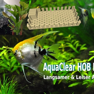 Può includere: Primo piano di un filtro AquaClear HOB con il testo "AquaClear HOB Filter" e "Langsamer & Leiser Auslauf" in tedesco. Il filtro è mostrato in un acquario con piante verdi e due pesci angelo argentati e gialli.