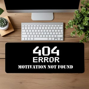 Könnte beinhalten: Schwarze Computer-Mausmatte mit weißem Text, der "404 ERROR MOTIVATION NOT FOUND" lautet.