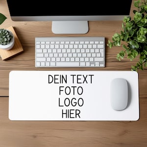 Könnte beinhalten: Weiße Schreibtischmatte mit dem Text "DEIN TEXT FOTO LOGO HIER" in Schwarz gedruckt. Eine weiße Computermaus liegt auf der Matte.