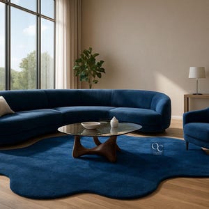 Pode incluir: Uma sala de estar moderna com um grande sof&aacute; azul curvo, uma poltrona a condizer e um tapete azul com uma forma org&acirc;nica &uacute;nica. Uma mesa de centro com tampo de vidro e base de madeira est&aacute; no centro. A sala tem janelas grandes e ch&atilde;o de madeira.