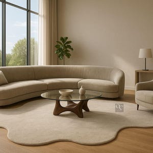 Pode incluir: Sala de estar moderna com sof&aacute; bege curvo, poltrona a condizer e mesa de centro com tampo de vidro. Tapete e ch&atilde;o bege. Uma l&acirc;mpada e um vaso decorativo completam o ambiente. O design &eacute; minimalista e elegante, com uma paleta de cores neutras.