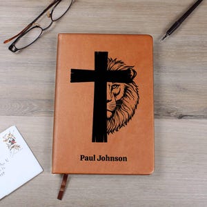 May include: A white ceramic mug with a black handle and the text "But First, Coffee" in a bold, black font. The mug is set against a blurred background, suggesting a cozy setting. The mug appears to be approximately 4 inches tall.