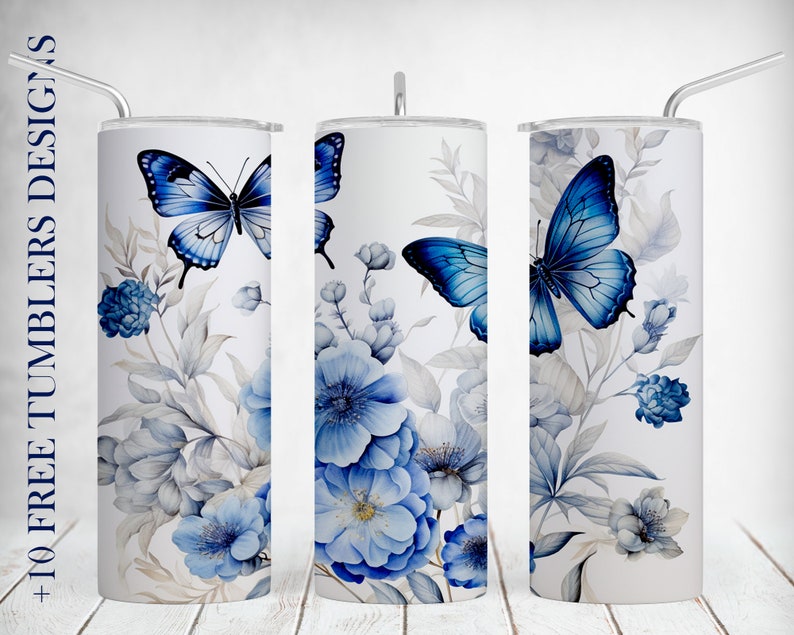 May include: Three white stainless steel tumblers with a blue butterfly and blue flowers design. The tumblers have lids and straws.