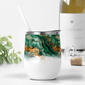 May include: A stainless steel wine tumbler with a green and gold marble design. The tumbler has a white lid and a white straw.
