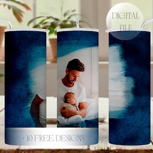 Puede incluir: Un juego de tres vasos de acero inoxidable con tapas y pajitas. Los vasos presentan un diseño de acuarela azul oscuro y una foto de un padre y un niño. El texto "+ 10 FREE DESIGNS" está impreso en la parte inferior.