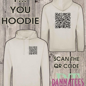 May include: A beige hoodie with a black QR code printed on the front and back. The text "F... YOU HOODIE" is printed on the front of the hoodie. The text "SCAN THE QR CODE" is printed below the QR code on the back of the hoodie. The text "DANNATEES" is printed below the QR code on the back of the hoodie.