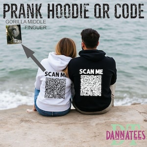 May include: Two hoodies, one white and one black, with QR codes printed on the back. The white hoodie says "SCAN ME" above the QR code. The black hoodie also says "SCAN ME" above its QR code. The image also includes the text "PRANK HOODIE QR CODE".