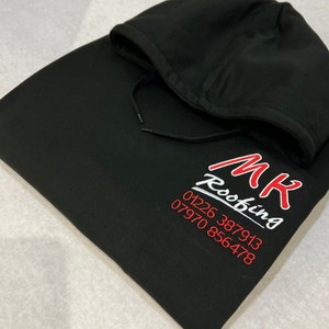 以下が含まれることがあります： 白い文字で「MK Roofing」と赤い文字で電話番号01226 387913と07970 856478が書かれた黒いフード付きスウェットシャツ。
