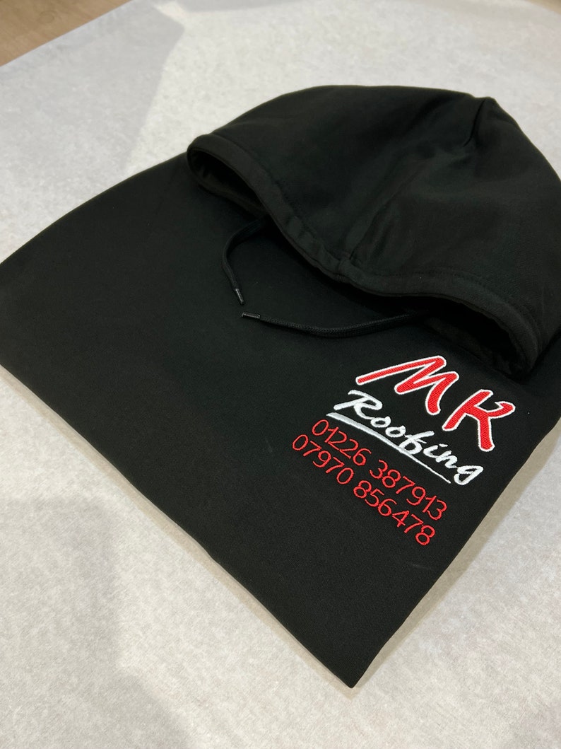以下が含まれることがあります： 白い文字で「MK Roofing」と赤い文字で電話番号01226 387913と07970 856478が書かれた黒いフード付きスウェットシャツ。