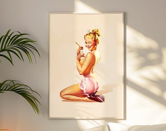 May include: A framed wall art print featuring a blonde pin-up figure kneeling while wearing pink ruffled shorts and dark heels. The figure holds a small bottle and looks over their shoulder with a wink against a light cream background.