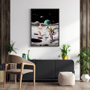May include: A framed collage art print depicting a man and woman playing golf on the moon. The moon is depicted with craters and a starry sky. The earth is visible in the background.