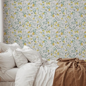 Puede incluir: Un dormitorio con una cama blanca con una manta marrón y almohadas blancas. La pared está cubierta con un papel tapiz con un patrón de hojas verdes y limones amarillos.