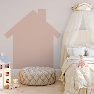 May include: A white canopy bed with a pink and white house painted on the wall behind it. A plush ottoman sits in front of the bed. A dollhouse and stuffed animals are on the floor.