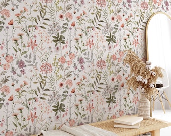 Op de afbeelding: Een witte bloemenbehang met een herhalend patroon van roze en groene bloemen en bladeren. De behang is te zien in een kamer met een houten bank en een spiegel.