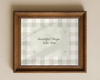 May include: A rectangular wooden frame containing a print with a sage green and white gingham pattern. Centered on the print is a light green rectangular panel with four small circles at the corners and the text "beautiful things take time."