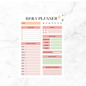 Peut inclure: Un planificateur quotidien rose et vert avec des sections pour la liste des choses à faire, l'humeur, le plan de repas, le plan d'action, l'apport en eau, une note pour soi et des rappels importants. Le planificateur a un champ de date et une section pour le jour de la semaine.