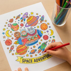 May include: A child coloring a space-themed illustration with a red pencil. The drawing features a rocket ship with astronauts and a rabbit, planets, stars, and the words "SPACE ADVENTURE". A glass of colored pencils sits nearby.
