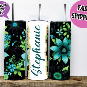 Könnte beinhalten: Drei Edelstahlbecher mit Deckel und Strohhalmen. Die Becher sind mit dem Namen "Stephanie" personalisiert und zeigen ein Blumenmuster mit grünen Blättern und blauen Blüten auf schwarzem Hintergrund.