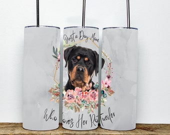 May include: A white tumbler with a floral design and a Rottweiler dog's face in the center. The text "Just a Dog Mom Who Loves Her Rottweiler" is printed on the tumbler.
