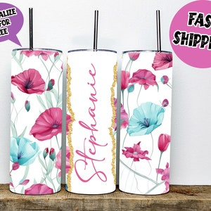 Könnte beinhalten: Drei Edelstahlbecher mit weißem Hintergrund und einem Blumendesign mit rosa und blauen Blumen. Der mittlere Becher trägt den Namen "Stephanie" in rosa Buchstaben.