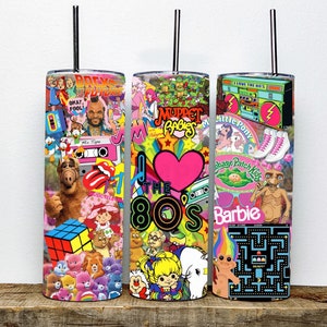 May include: Three stainless steel tumblers with colorful 1980s themed designs. The designs include characters from the Muppet Babies, Care Bears, Cabbage Patch Kids, My Little Pony, and E.T. The tumblers have pink, blue, and black straws.