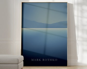 May include: A framed print of a minimalist landscape painting in shades of blue. The painting depicts a body of water with a mountain range in the background. The artist's name, "MARK ROTHKO", is printed in white at the bottom of the print.