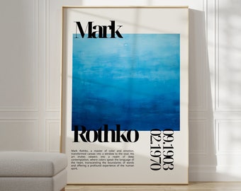 Può includere: Un poster incorniciato con un dipinto astratto blu e il testo "Mark Rothko 09.1903 - 02.1970". Il poster è appeso a una parete bianca con un pouf grigio chiaro in primo piano.